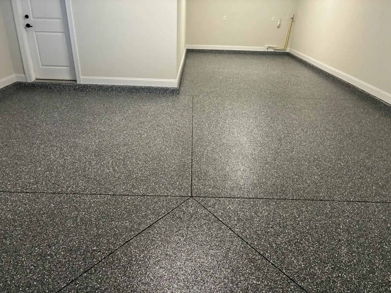 Gray flake epoxy garage floor with the control joints cut through and sealed