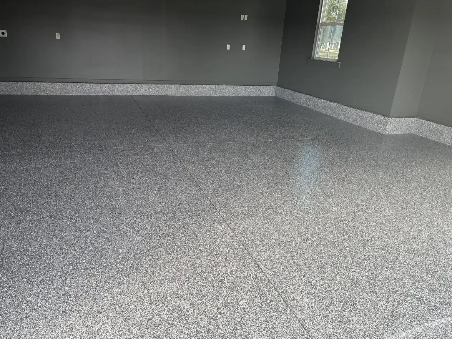 Light gray flake epoxy garage floor against charcoal painted walls