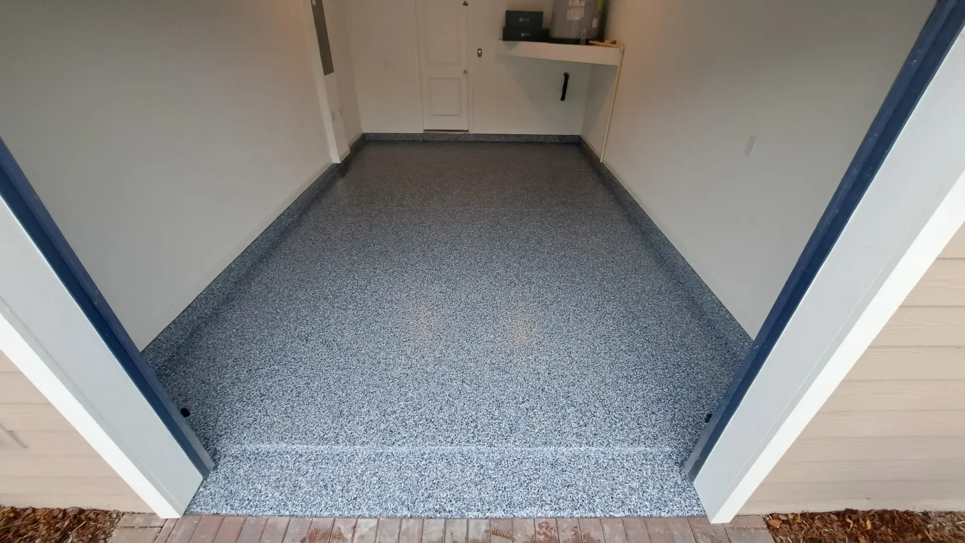 Narrow single garage bay in a blue and white flake epoxy floor