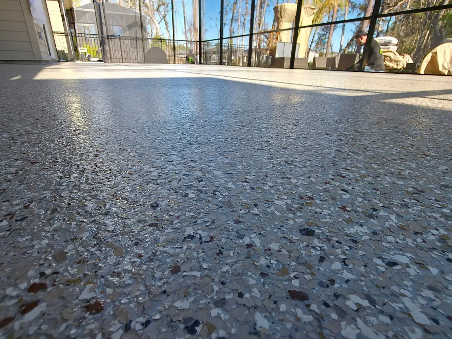 Close view of a multicolor flake coating on a screened lanai floor