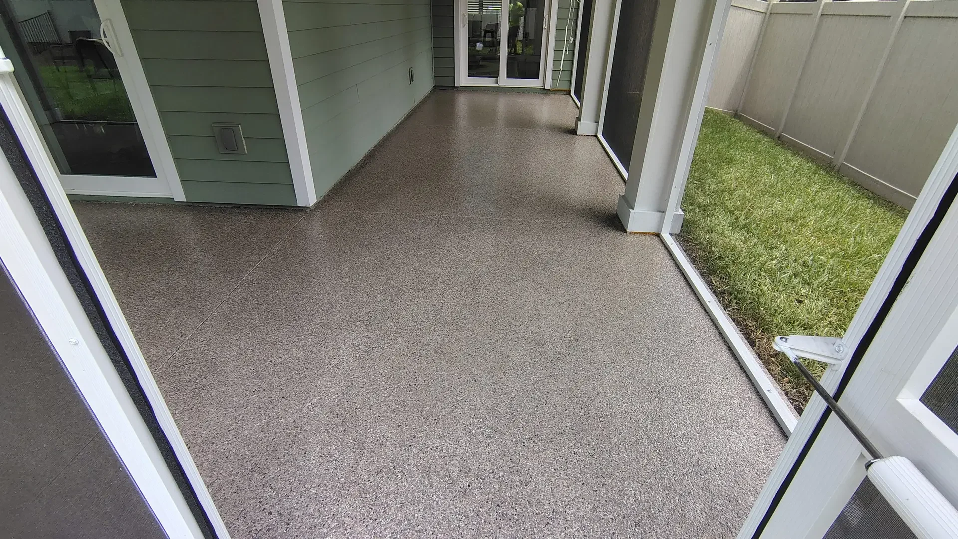 Warm gray flake coating on a screened porch beside green siding