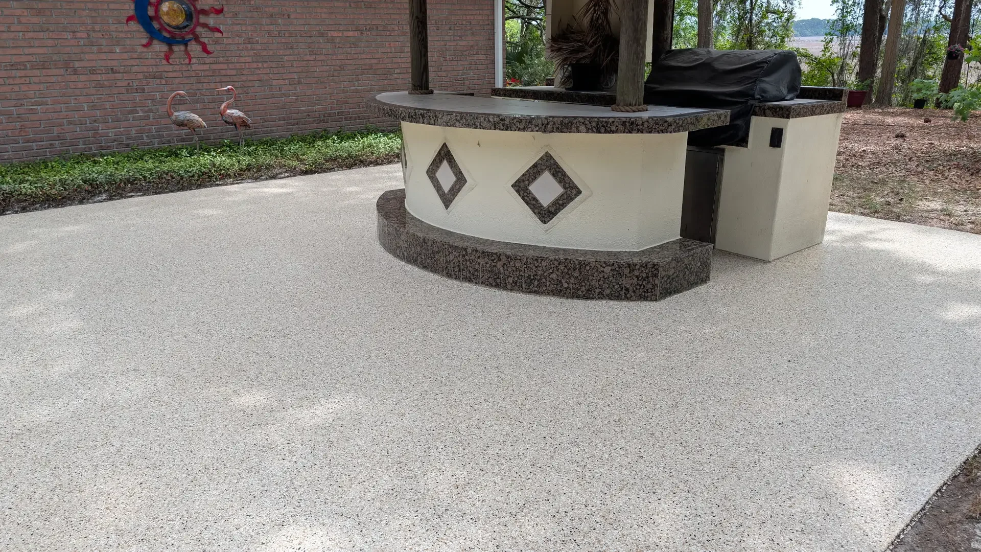 Light flake coating on an open patio around an outdoor kitchen island